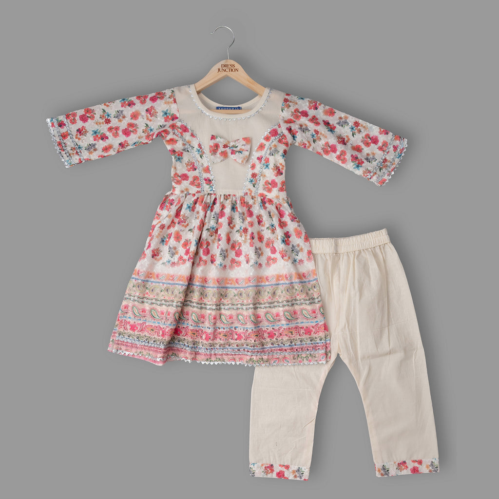 Floral dress and beige pants set on a gray background