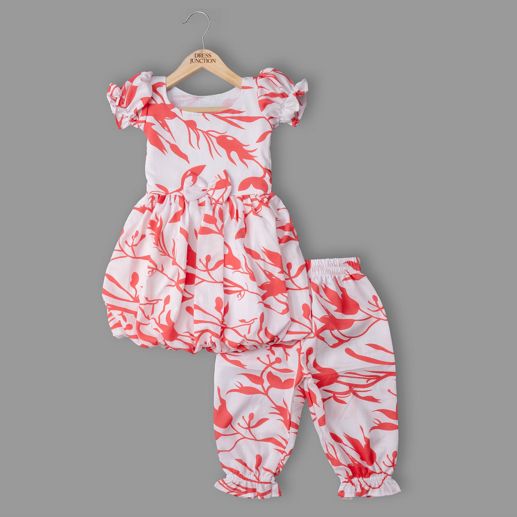 Children's outfit with red and white floral pattern on a gray background