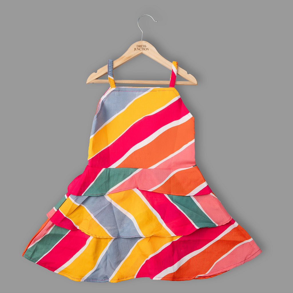 Colorful striped dress on a hanger against a gray background