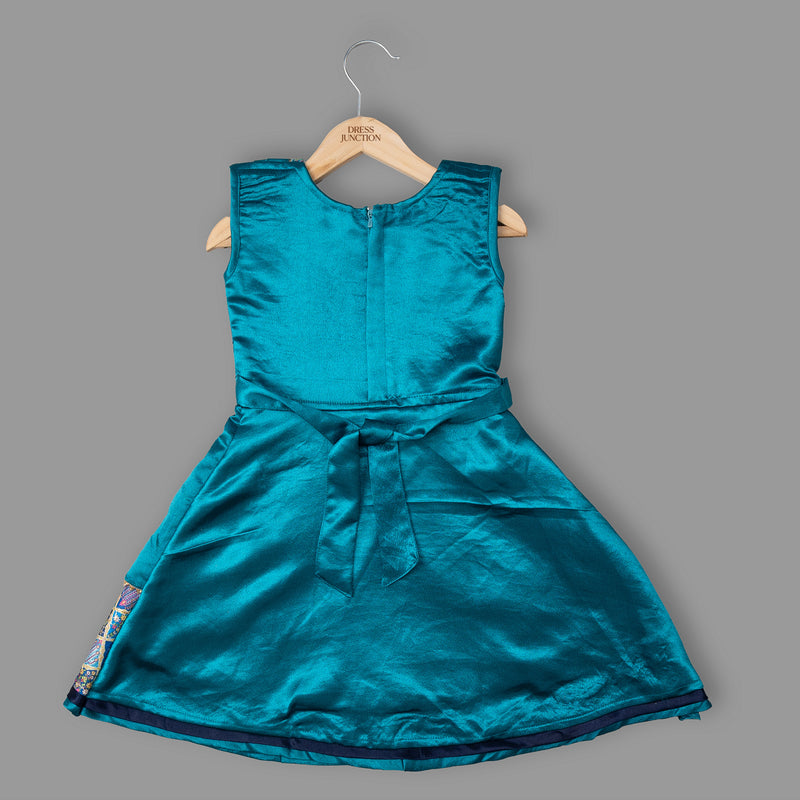 Teal dress on a hanger against a gray background