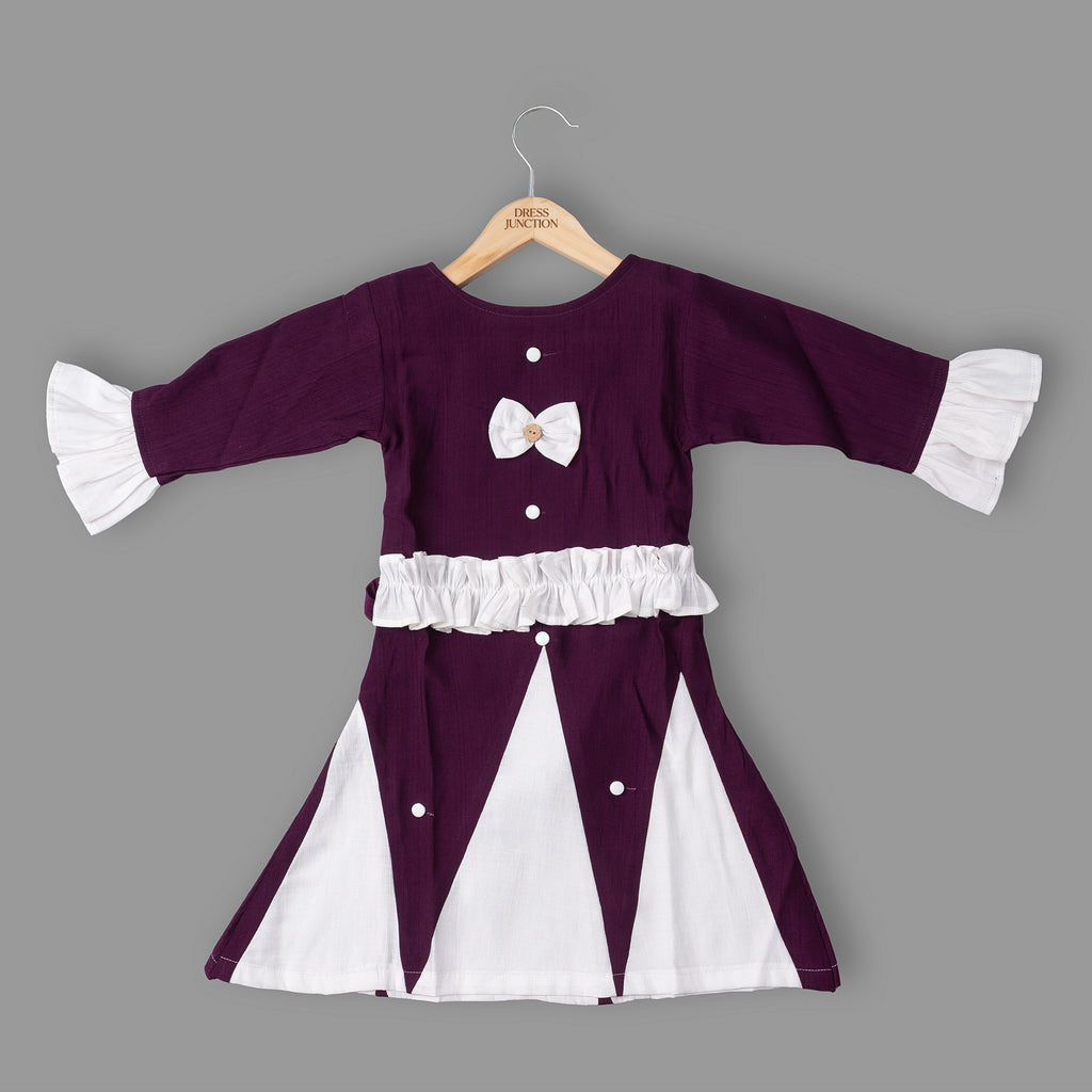 Purple and white dress with ruffled sleeves on a hanger against a gray background