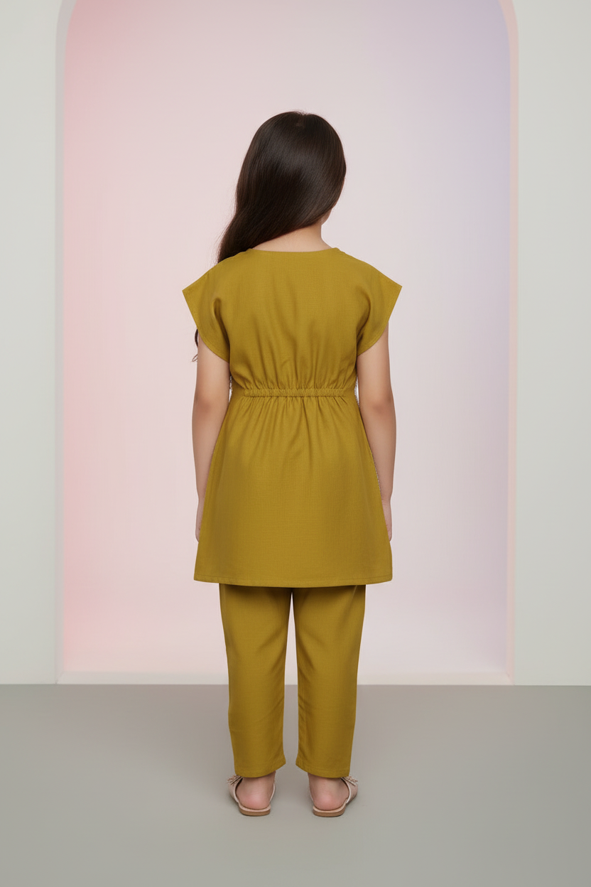 Mustard yellow top and pants set on a hanger against a gray background
