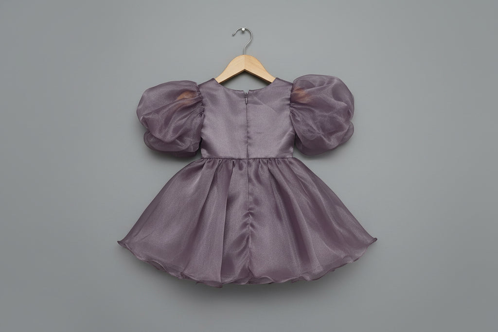 Purple dress with puffed sleeves on a wall