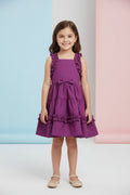 Purple dress with ruffles on a wooden hanger against a gray background